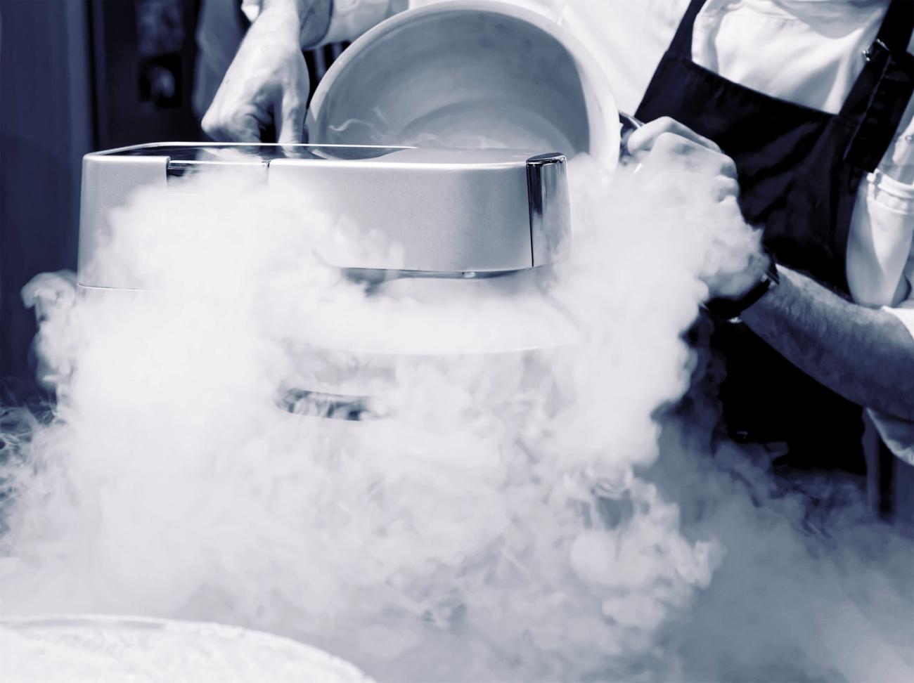A silver cryogenic vessel venting dense white vapour during a low-temperature process.